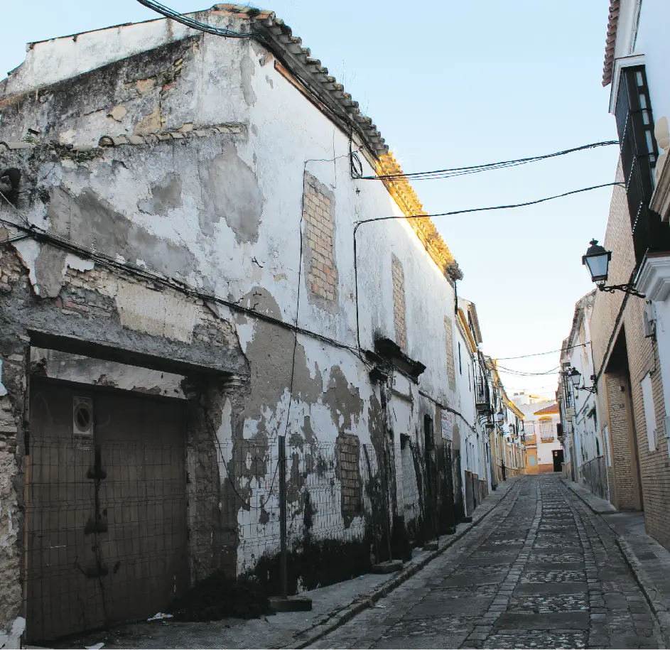 Calle secundaria andaluza, con edificios olvidados en situación de ruina, con vallados, suciedad y humedades. // Gorka Fernández