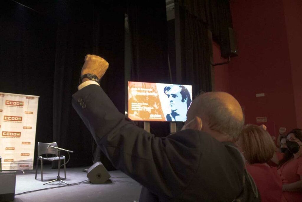 Carmelo Acuña, levantando el puño izquierdo, mientras se canta «La Internacional»
